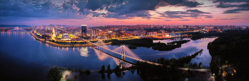 Aussicht auf die Innenstadt Krasnojarsk, die Brücke durch den Fluss Jenisei, Sonnenuntergang, Luftaufnahmen